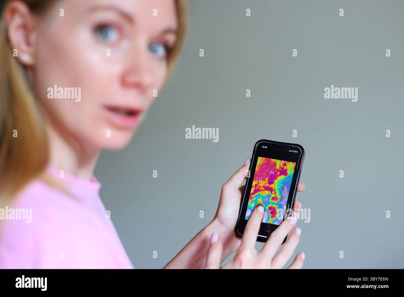 Avviso app meteo di emergenza, giovane donna reagisce all'avvicinarsi della tempesta, consapevolezza del rischio climatico. Foto Stock