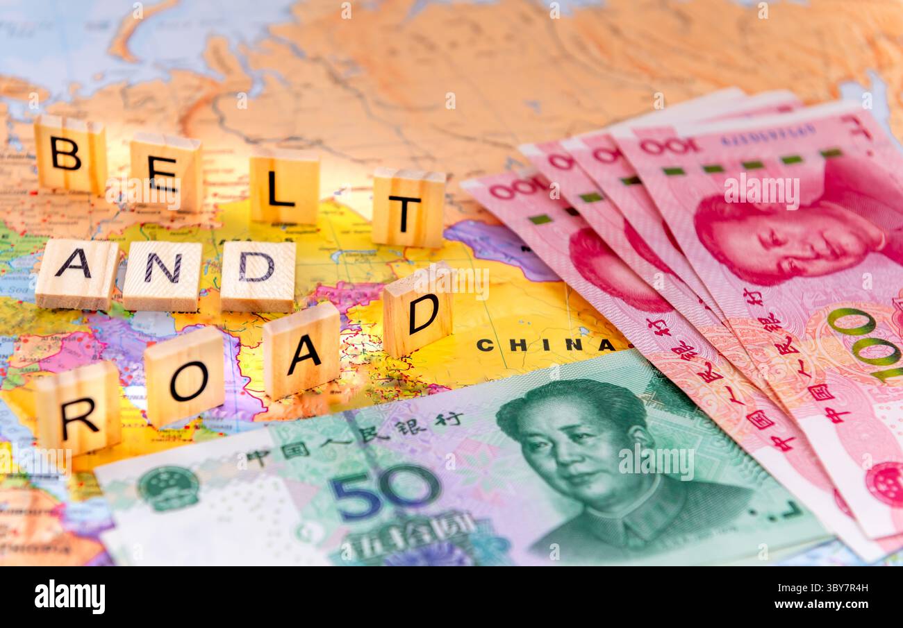 Un concetto di Belt and Road Initiative con piastrelle di lettere e banconote in Yuan cinese su una mappa della Cina. Foto Stock