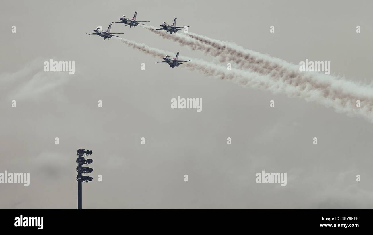 USAF Thunderbirds in stretta formazione di diamanti con sentieri di fumo durante un'esposizione aerea a McGuire AFB, New Jersey, 16 maggio 2025. Stadium Light aggiunge s. Foto Stock
