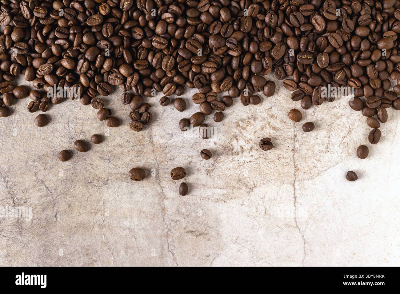Chicchi di caffè sparsi su carta d'epoca, sfondo alimentare Foto Stock