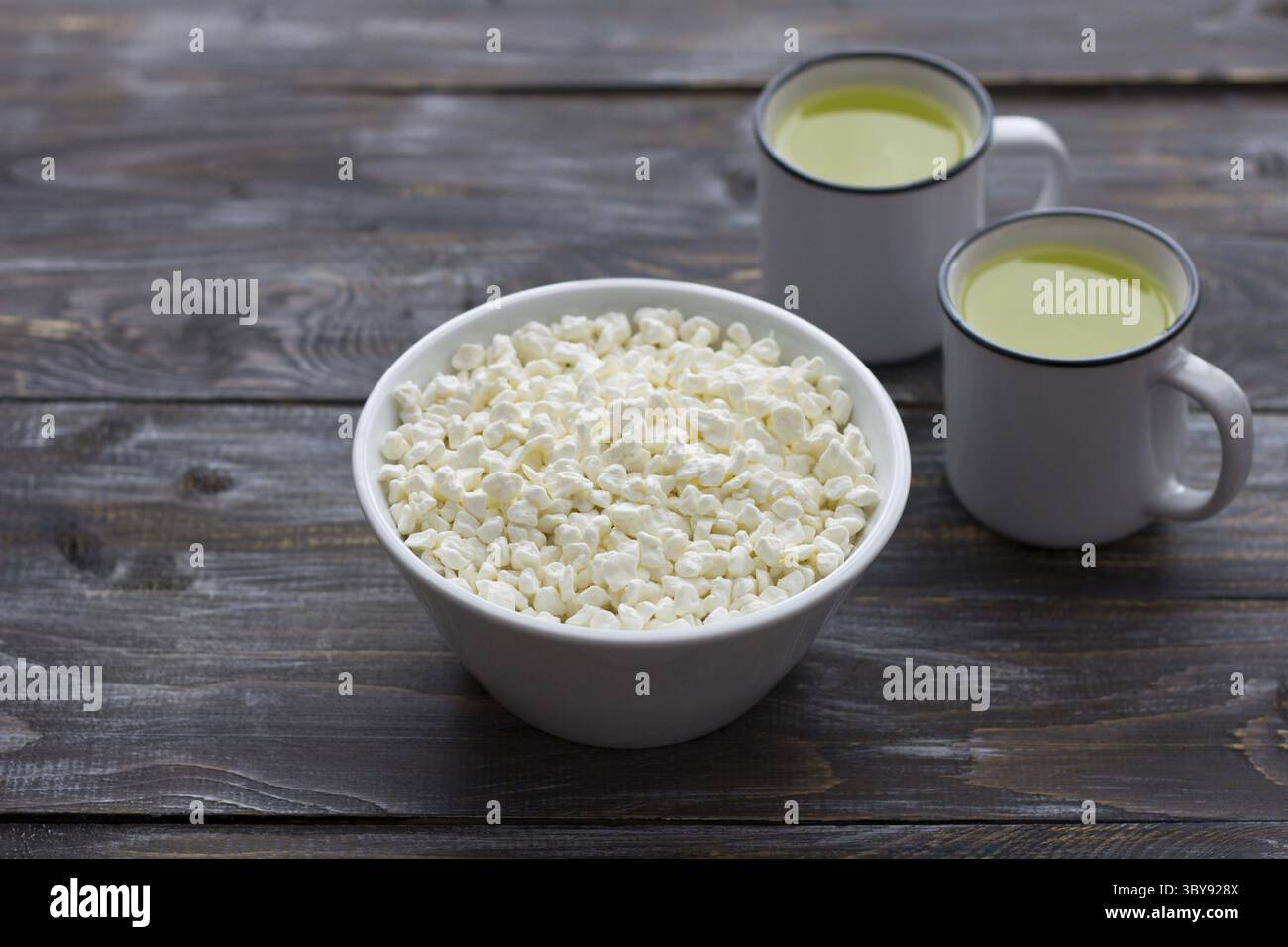 Cibo, formaggio fresco fatto in casa e siero di latte su sfondo di legno Foto Stock