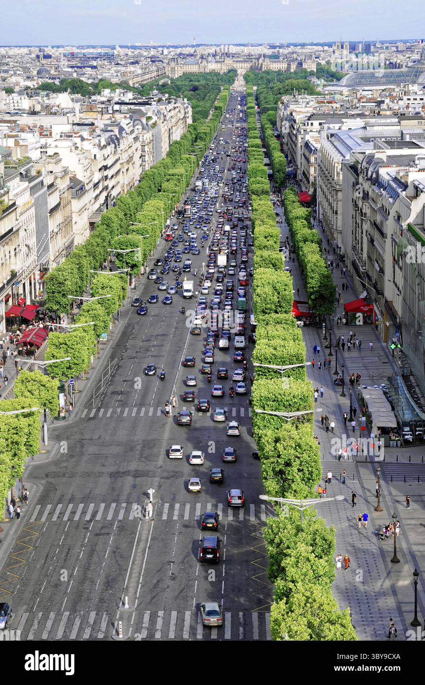 Traffico intenso sull'Avenue des Champs-Elysees fiancheggiato da alberi verdi ed edifici, Parigi, Francia Foto Stock