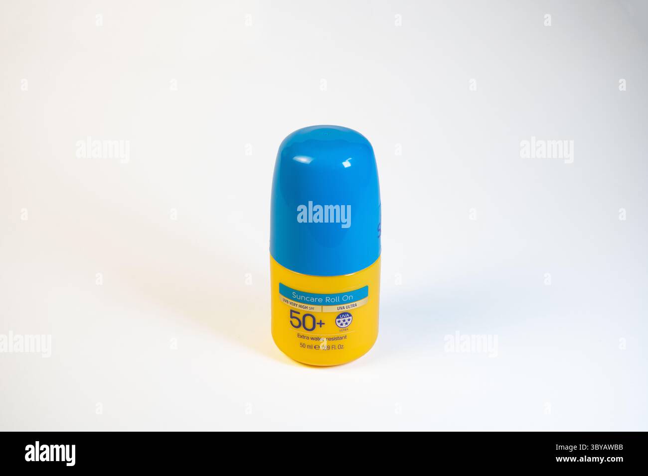 Protezione solare roll-on fattore 50+ giallo con coperchio blu, isolata su sfondo bianco pulito. Foto di un prodotto semplice per la cura del sole, la cura della pelle e le protec estive Foto Stock