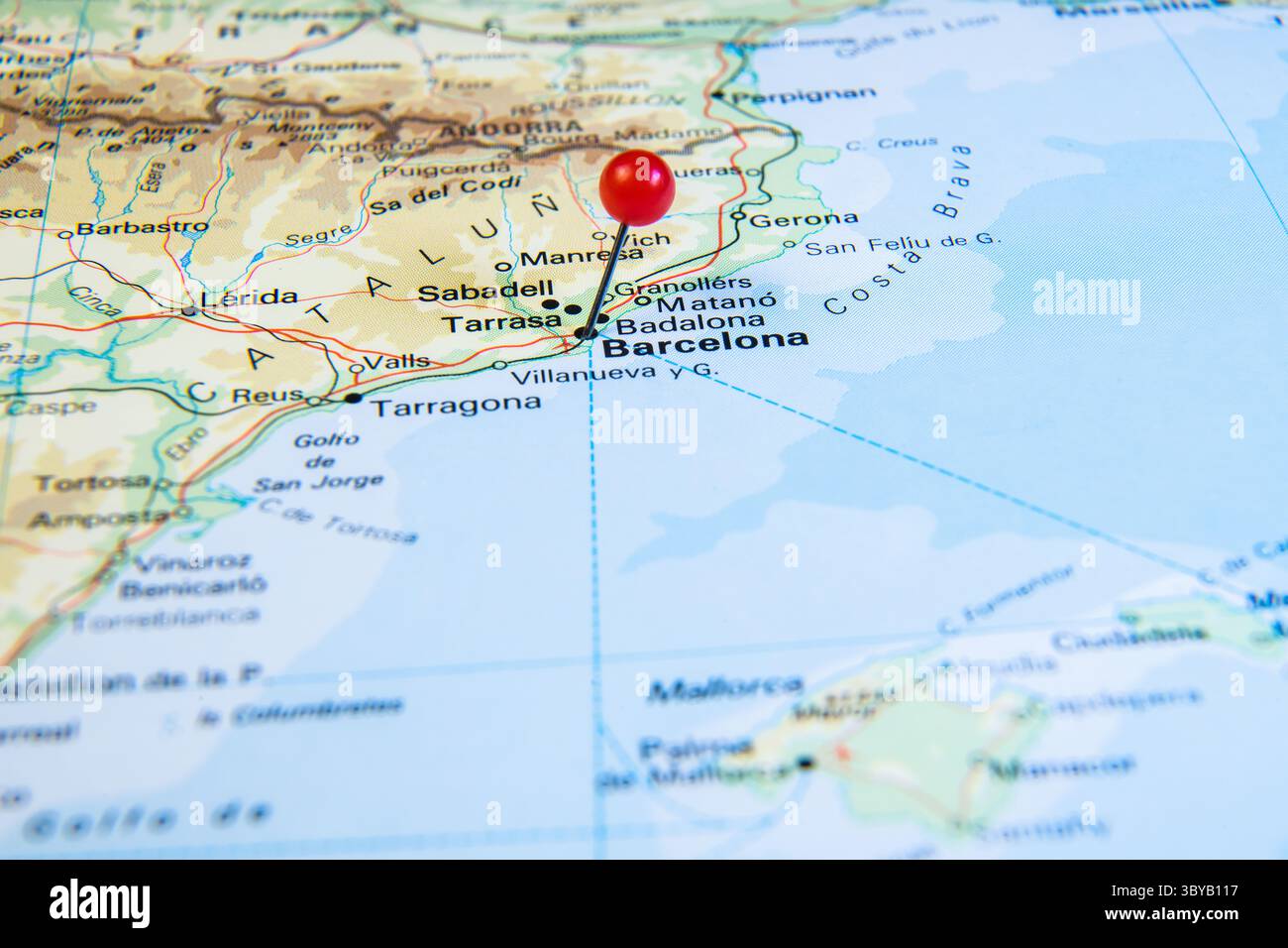 Una mappa ravvicinata della Spagna nord-orientale e della Francia meridionale con una spilla rossa che segna Barcellona, mostrando le principali città e le regioni costiere vicino alle Baleari Foto Stock