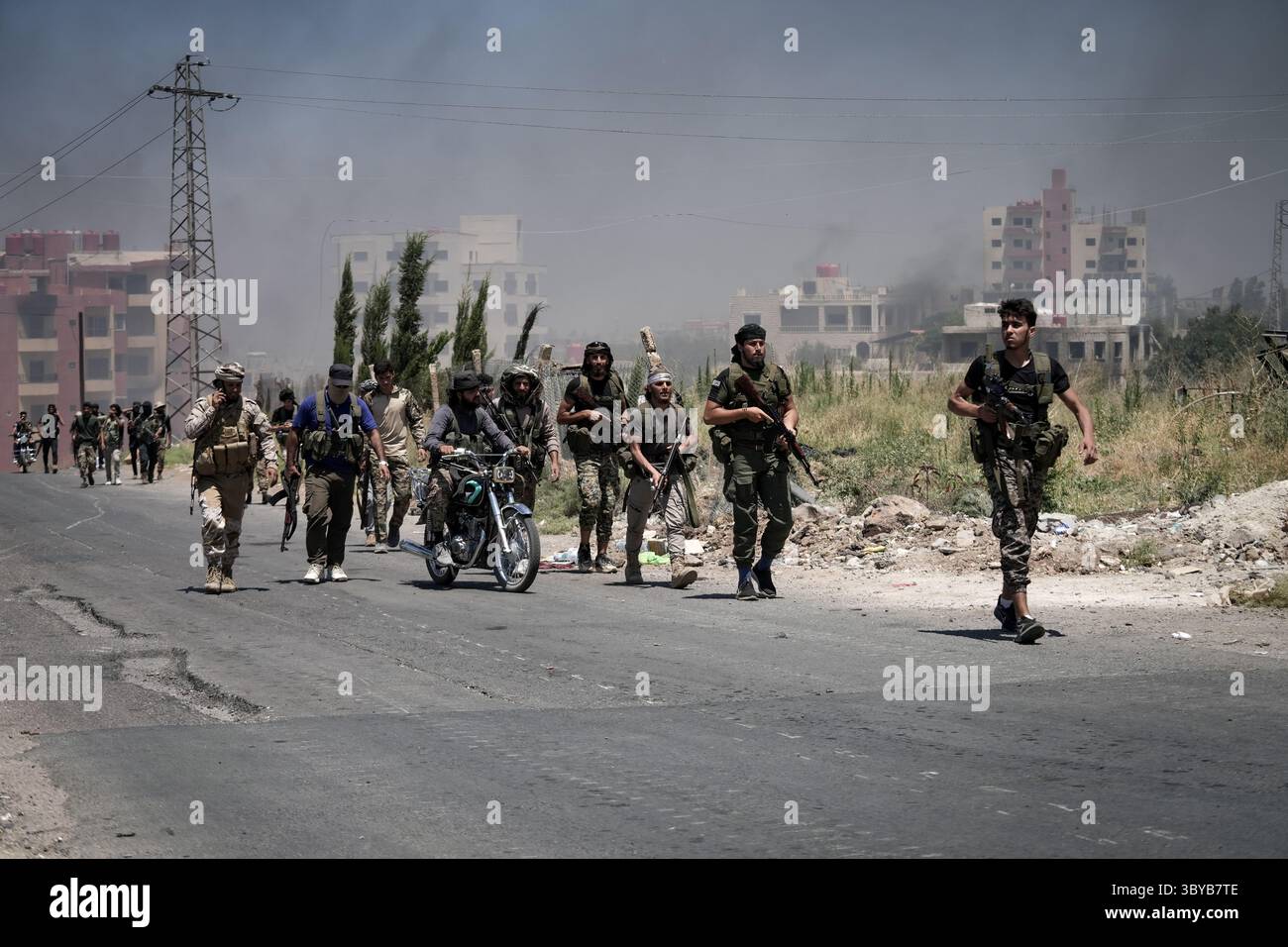 Come Suwayda, Siria. 19 luglio 2025. I beduini e i combattenti tribali si riuniscono nella città di AS-Suwayda, mentre il fumo sale dalle case in fiamme tra gli scontri tra i combattenti tribali e le fazioni druse locali nel sud della Siria. Paura e shock colpiscono la provincia a seguito dell'escalation di scontri isolati in uno dei più letali focolai di violenza che la regione abbia mai visto negli ultimi anni. Crediti: Moawia Atrash/dpa/Alamy Live News Foto Stock