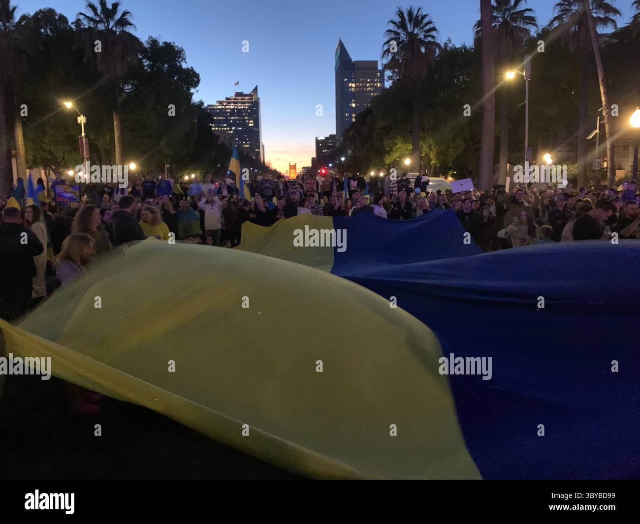 27 febbraio 2022, Sacramento, California, USA: I colori del Campidoglio della California sono stati cambiati in blu e giallo per mostrare sostegno all'Ucraina, mentre le persone si riuniscono di fronte all'edificio per protestare contro l'invasione russa dell'Ucraina. Un grande striscione giallo dice: "Dio protegga l'Ucraina". (Immagine di credito: © Andrew Silk/ZUMA Press Wire Service) Foto Stock