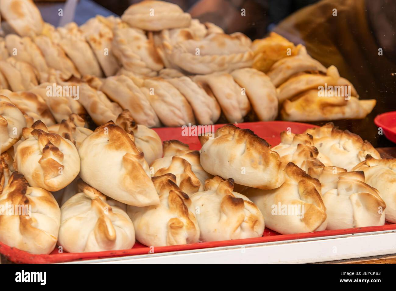 Primo piano di un display con un gran numero di empanadas appena preparate Foto Stock