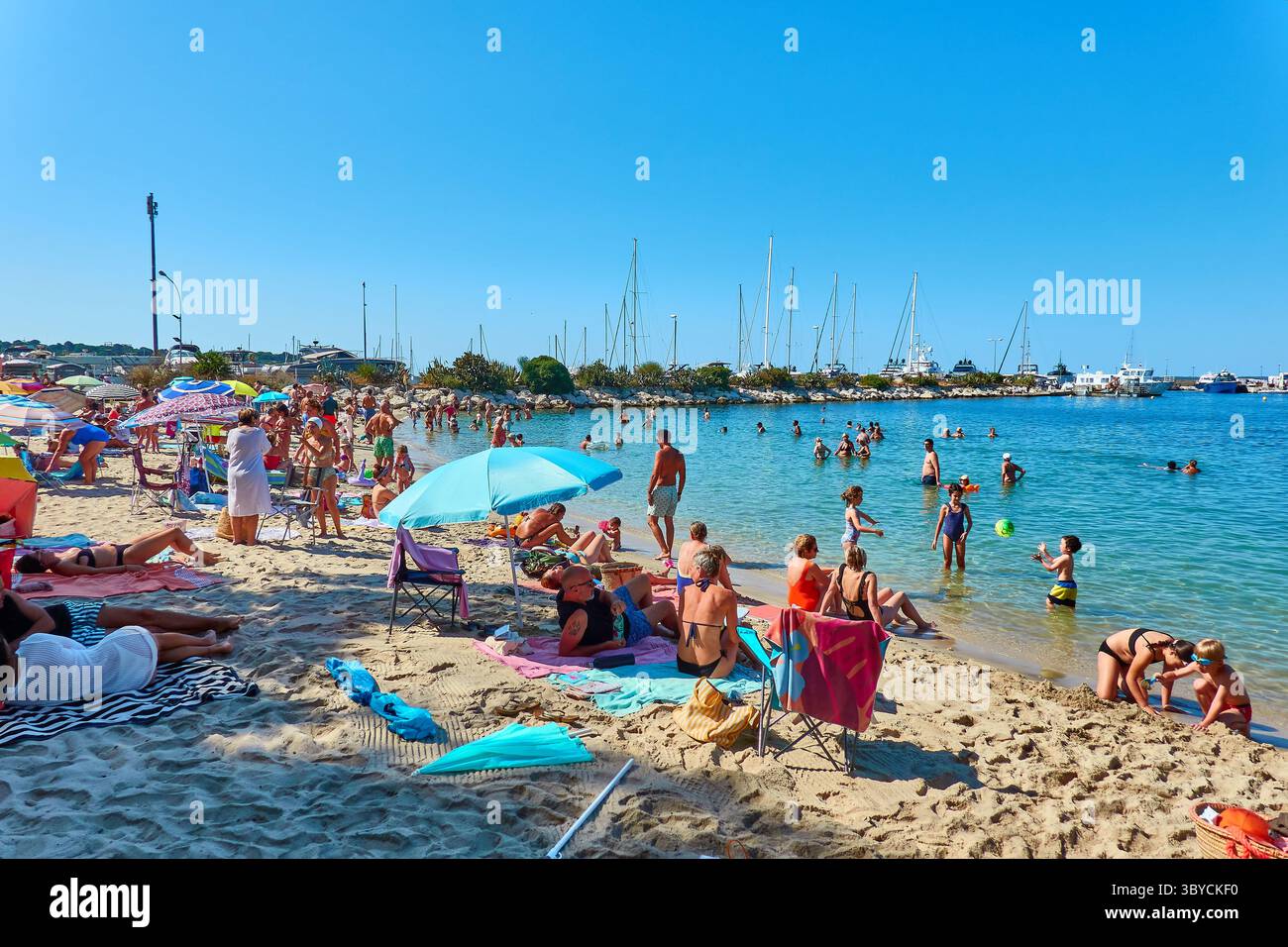 Affollata spiaggia di sabbia nel sud della Francia con visitatori rilassanti e vibrante atmosfera estiva Foto Stock