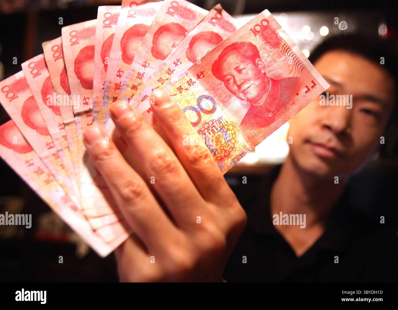 23 giugno 2010, PECHINO, CINA: Un dipendente di una banca detiene banconote da 100 RMB (15 USD) a Pechino il 23 giugno 2010. La Cina ha subito una crescente pressione internazionale per cambiare la sua politica monetaria. Gli Stati Uniti si sono lamentati del fatto che la Cina stia artificialmente mantenendo basso il valore dello yuan per aiutare i suoi esportatori a spese dei concorrenti stranieri. (Immagine di credito: © Stephen Shaver/ZUMA Press Wire) Foto Stock