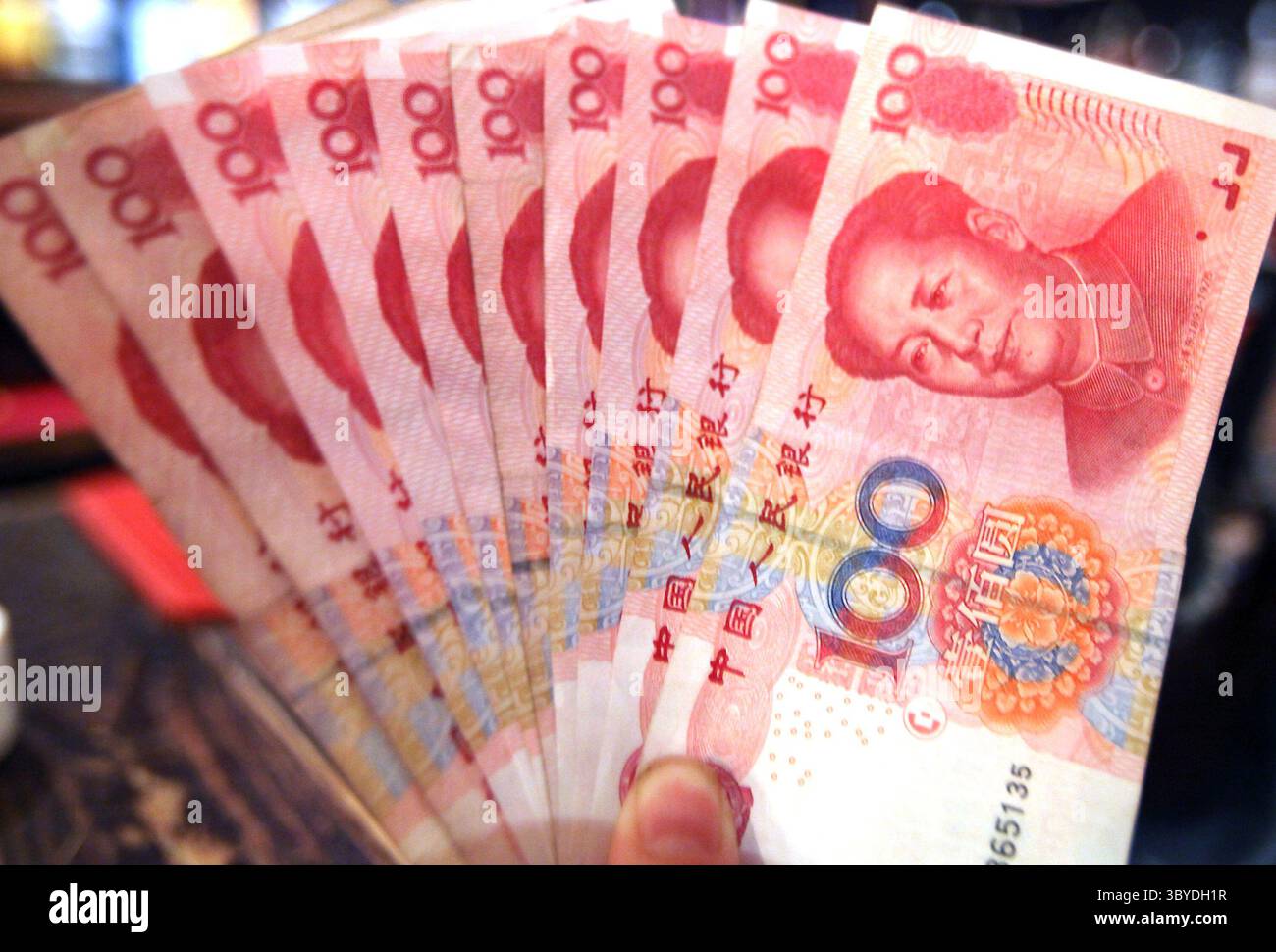 23 giugno 2010, PECHINO, CINA: Un dipendente di una banca detiene banconote da 100 RMB (15 USD) a Pechino il 23 giugno 2010. La Cina ha subito una crescente pressione internazionale per cambiare la sua politica monetaria. Gli Stati Uniti si sono lamentati del fatto che la Cina stia artificialmente mantenendo basso il valore dello yuan per aiutare i suoi esportatori a spese dei concorrenti stranieri. (Immagine di credito: © Stephen Shaver/ZUMA Press Wire) Foto Stock