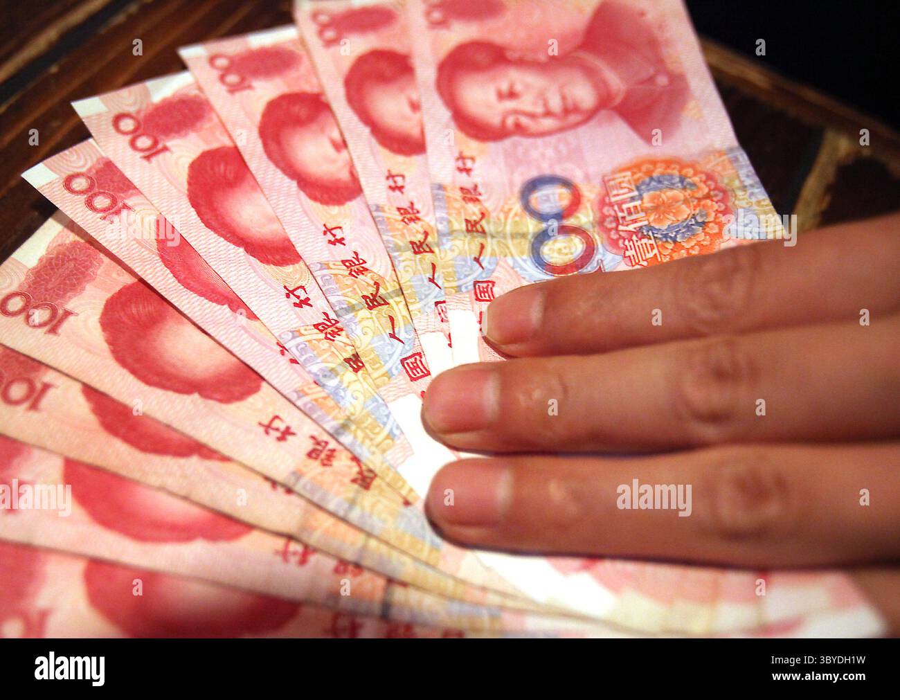 23 giugno 2010, PECHINO, CINA: Un dipendente di una banca detiene banconote da 100 RMB (15 USD) a Pechino il 23 giugno 2010. La Cina ha subito una crescente pressione internazionale per cambiare la sua politica monetaria. Gli Stati Uniti si sono lamentati del fatto che la Cina stia artificialmente mantenendo basso il valore dello yuan per aiutare i suoi esportatori a spese dei concorrenti stranieri. (Immagine di credito: © Stephen Shaver/ZUMA Press Wire) Foto Stock