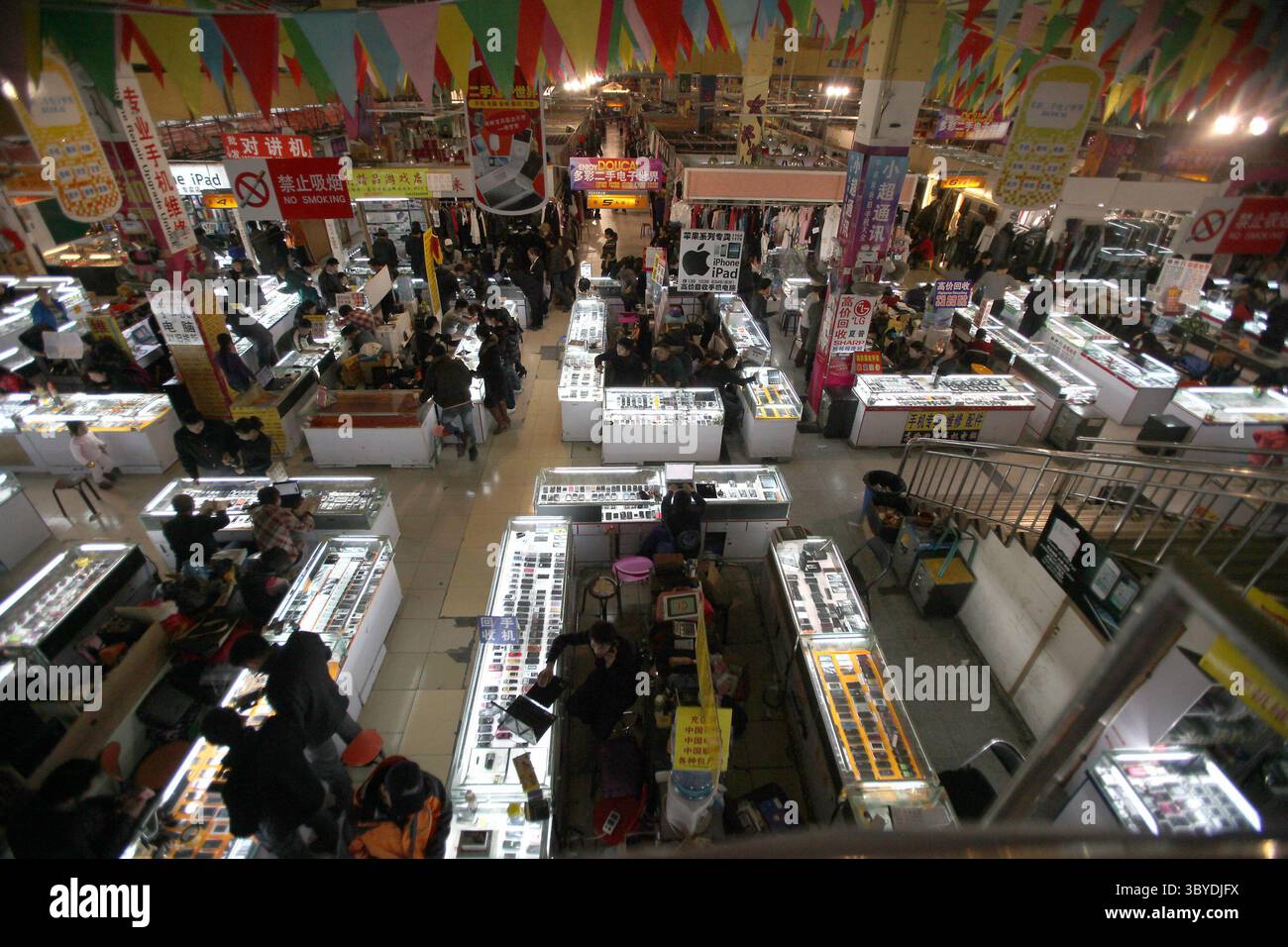 14 dicembre 2010, PECHINO, CINA: I clienti cinesi fanno acquisti in un popolare mercato dell'elettronica, ampiamente noto per la vendita di telefoni cellulari, software e computer contraffatti e piratati, in particolare iPhone e iPad, a Pechino il 14 dicembre 2010. La Cina ha annunciato il mese scorso una nuova repressione sulla pirateria dei prodotti e sulle violazioni dei diritti di proprietà intellettuale dopo la continua pressione da parte dei governi degli Stati Uniti e dell'Europa. (Immagine di credito: © Stephen Shaver/ZUMA Press Wire) Foto Stock