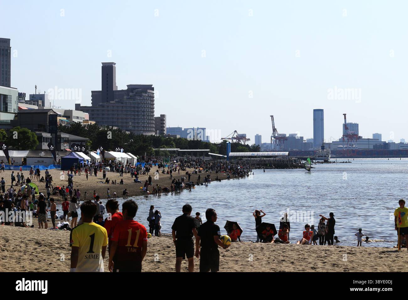 Vita quotidiana in Giappone persone che si godono un evento sportivo sulla spiaggia artificiale di Odaiba Seaside Park Foto Stock