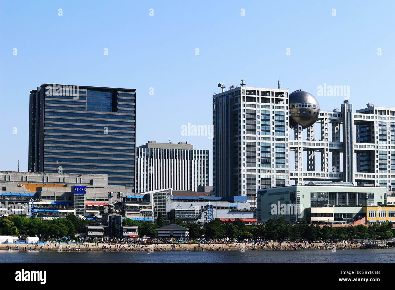 Vita quotidiana in Giappone Una vista panoramica della affollata spiaggia di sabbia artificiale del parco marino di Odaiba e delle strutture per il tempo libero sul lungomare Foto Stock