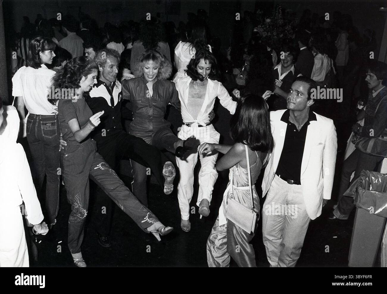 Intorno al 1983: Promotore di concerti RON DELSENER line balla ad una danza di linea party (Delsener è il secondo da sinistra). Delsener, nativo di New York, ha iniziato a lavorare per il promotore che ha messo in scena il primo concerto all'aperto dei Beatles al Forest Hills Tennis Stadium nel Queens. (Immagine di credito: © John bellissimo/Retna via ZUMA Press Wire) Foto Stock