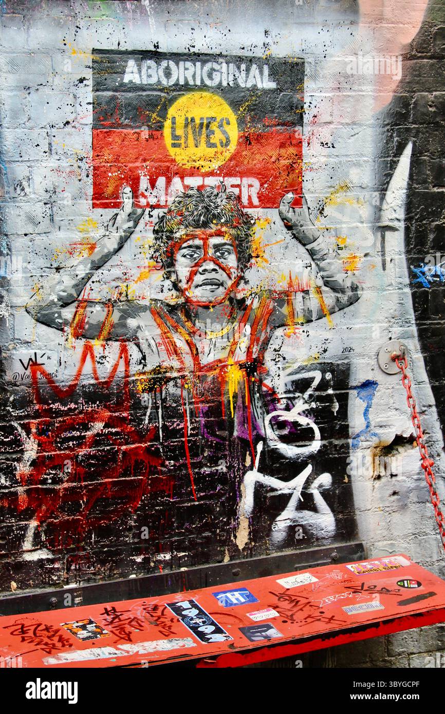 L'arte di Melbourne Street di un bambino indigeno che tiene la bandiera aborigena dicendo che le vite aborigene contano. Foto Stock