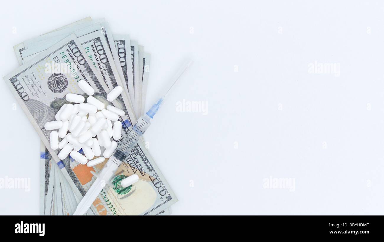 Pile di contanti accompagnate da pillole bianche e una siringa su una superficie pulita, evidenziando l'intersezione di sanità, finanza e uso di sostanze Foto Stock