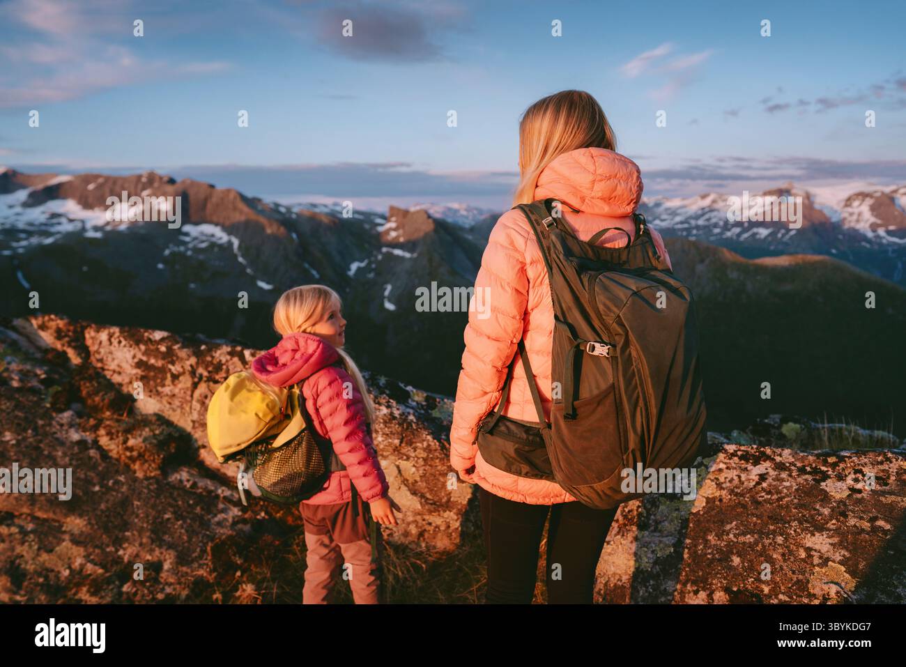 Escursioni in famiglia in Norvegia durante le vacanze estive, madre e figlia scalano le montagne e godono della vista del tramonto. Avventura all'aria aperta con stile di vita attivo Foto Stock