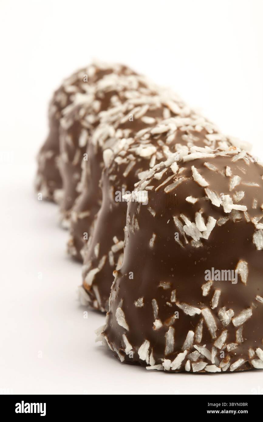 Un delizioso Flødebolle danese, caratterizzato da un soffice centro crema di marshmallow ricoperto di ricco cioccolato e abbondantemente cosparso di cocco grattugiato Foto Stock