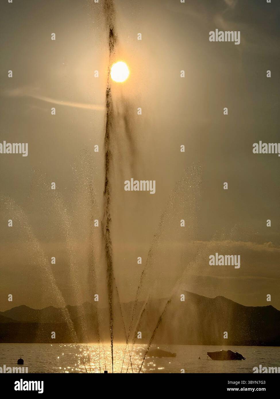Fontana retroilluminata dal sole della tarda sera nel porto di Bardolino sul Lago di Garda, Italia Foto Stock
