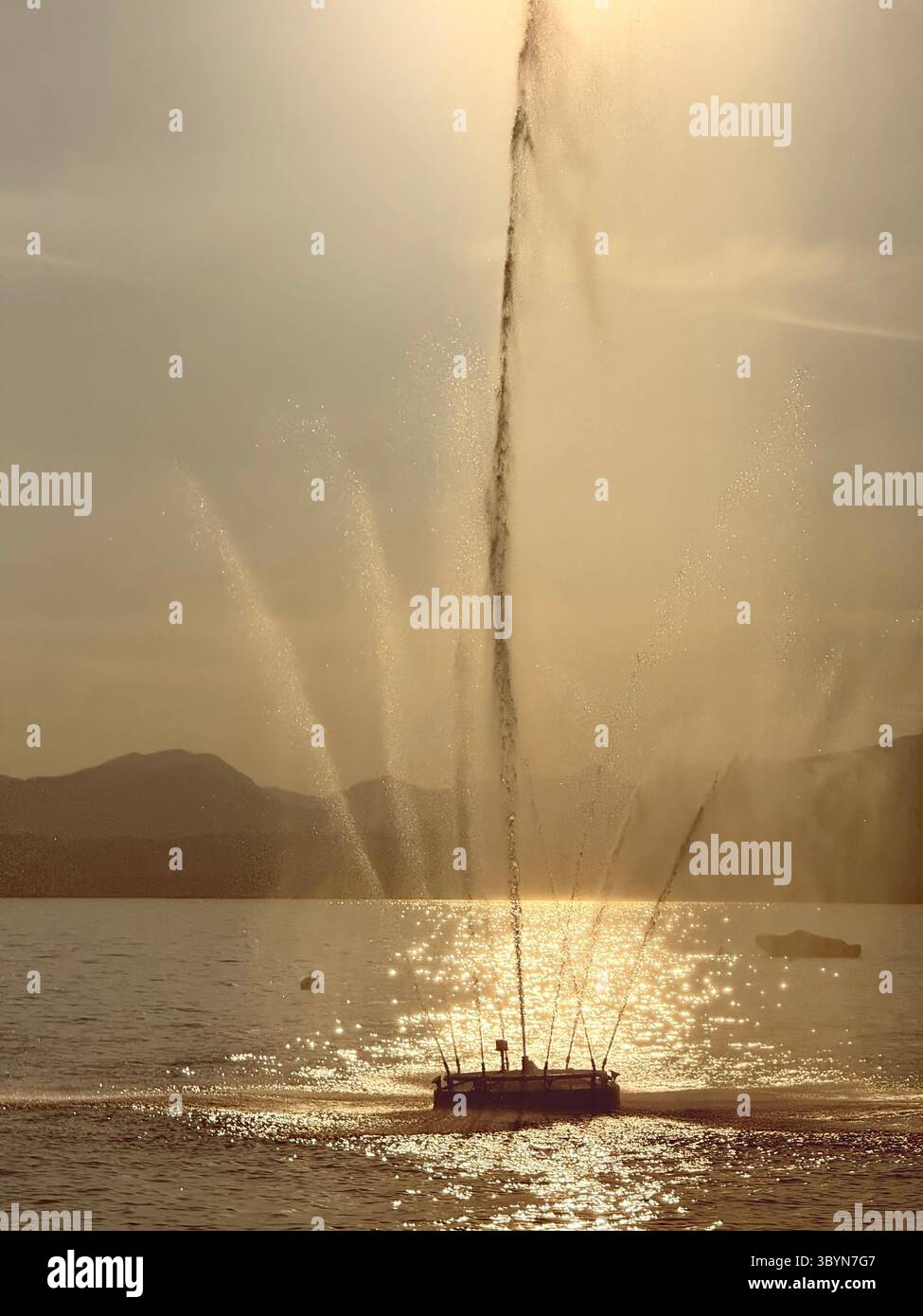 Fontana retroilluminata dal sole della tarda sera nel porto di Bardolino sul Lago di Garda, Italia Foto Stock