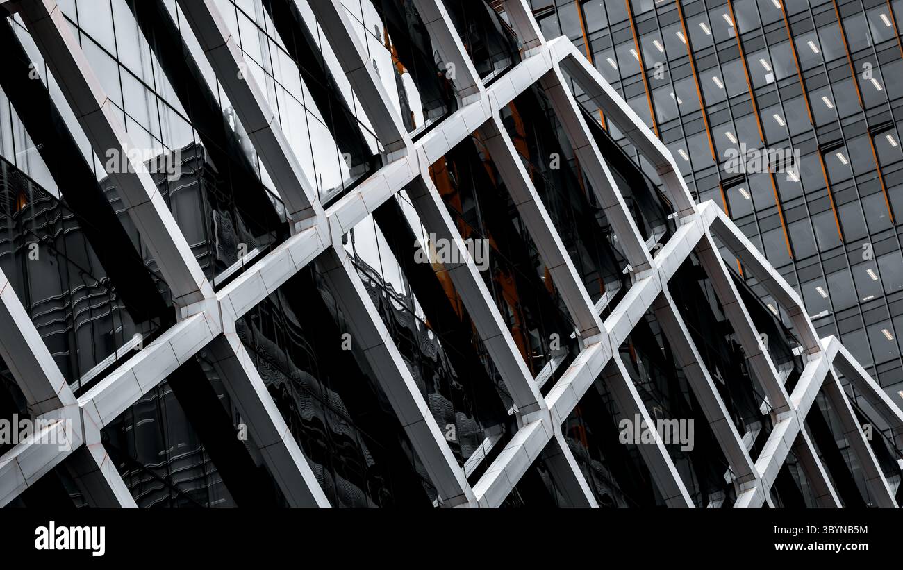 Astratto architettonico. Esterno moderno e generico di un edificio in bianco e nero con accenti arancioni. Struttura tubolare su vetro. Foto Stock