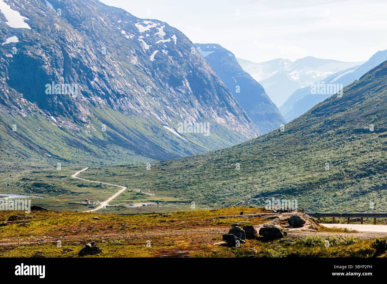 Norwegian Scenic Route 63 , Norvegia,. Lo splendido paesaggio montano presenta una strada tortuosa attraverso la vibrante valle, circondata da torreggianti scogliere e serena Foto Stock