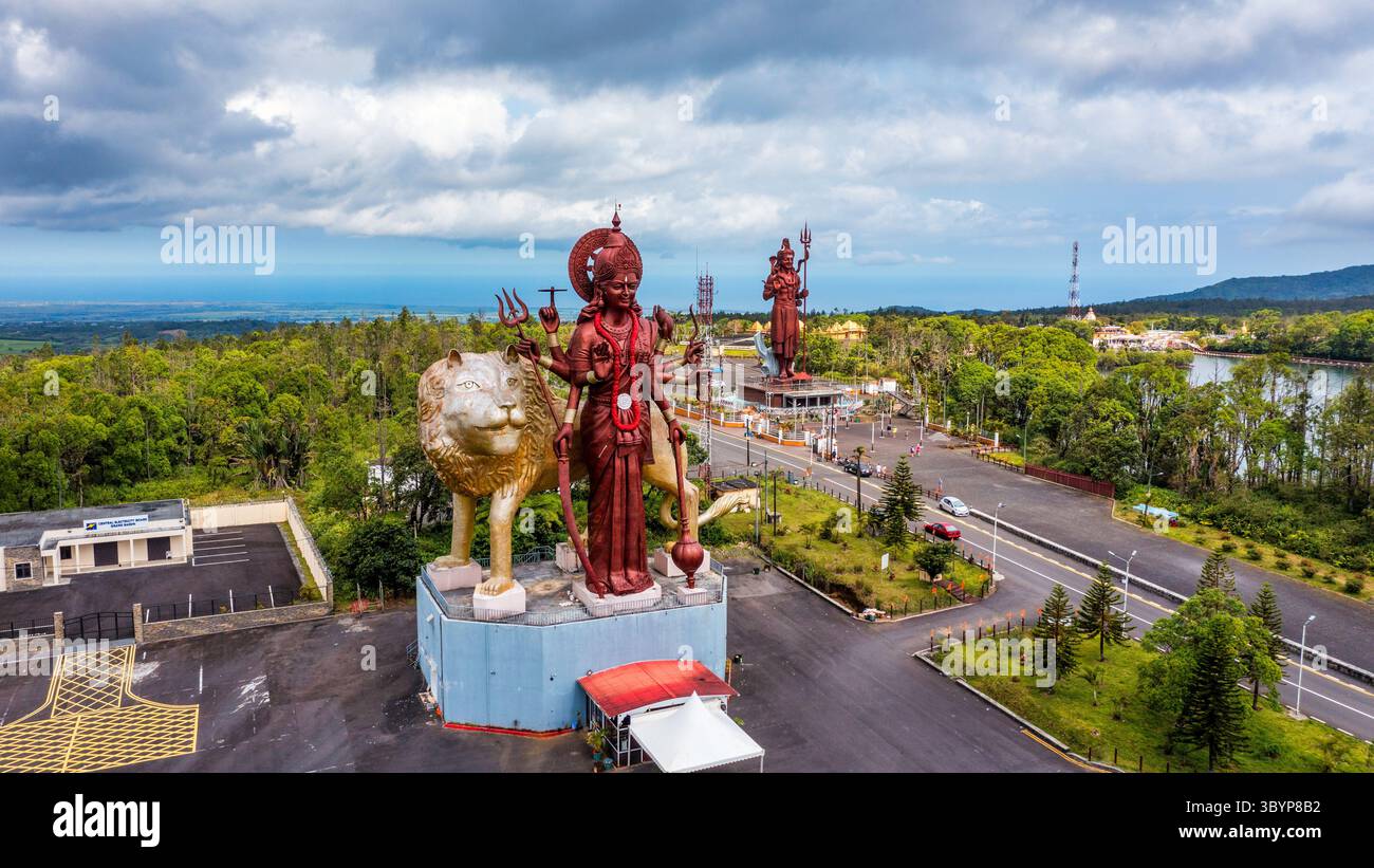 Una potente statua della dea indù Durga Maa con un leone dorato nel sacro Ganga Talao. Statua di Shiva al tempio di Grand Bassin, il più alto SH del mondo Foto Stock