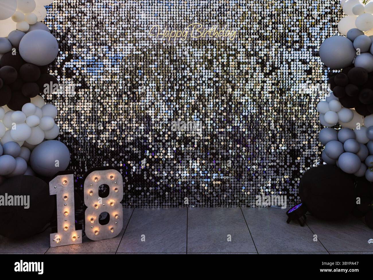 Organizzazione per festeggiare il compleanno con un messaggio di buon compleanno e 18 numeri illuminati Foto Stock