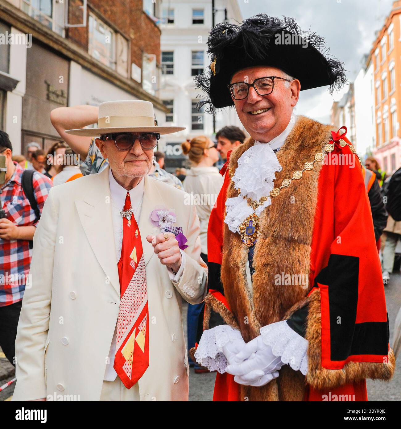 Londra, Regno Unito. 20 luglio 2025. 'Soho George', George Skeggs (a sinistra) un'istituzione Soho impeccabilmente vestita, posa con il sindaco di Westminster, Cllr Paul Dimoldenberg (a destra) nella sua vivace uniforme cerimoniale rossa alla gara. L'annuale London Waiters' Race vede ancora una volta decine di camerieri, cameriere e personale di servizio correre a piedi per le strade di Soho, tenendo in mano un vassoio con champagne e bicchieri, che deve arrivare al traguardo intatto. La gara è una tradizione di Soho che attrae londinesi e visitatori. Crediti: Imageplotter/Alamy Live News Foto Stock