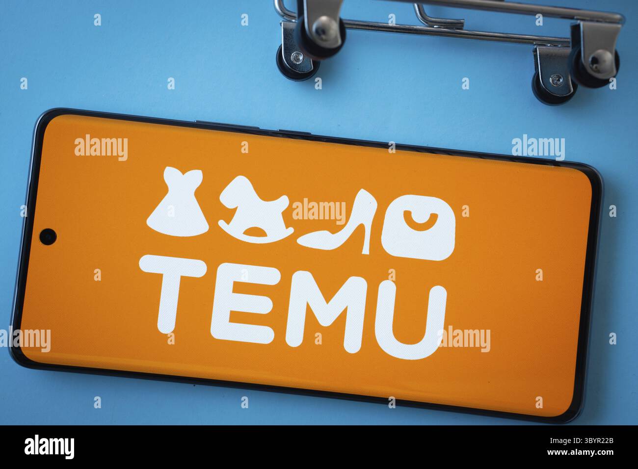 Dhaka, Bangladesh - 3 luglio 2025: Schermata dello smartphone con il logo Temu con le ruote del carrello su sfondo blu Foto Stock