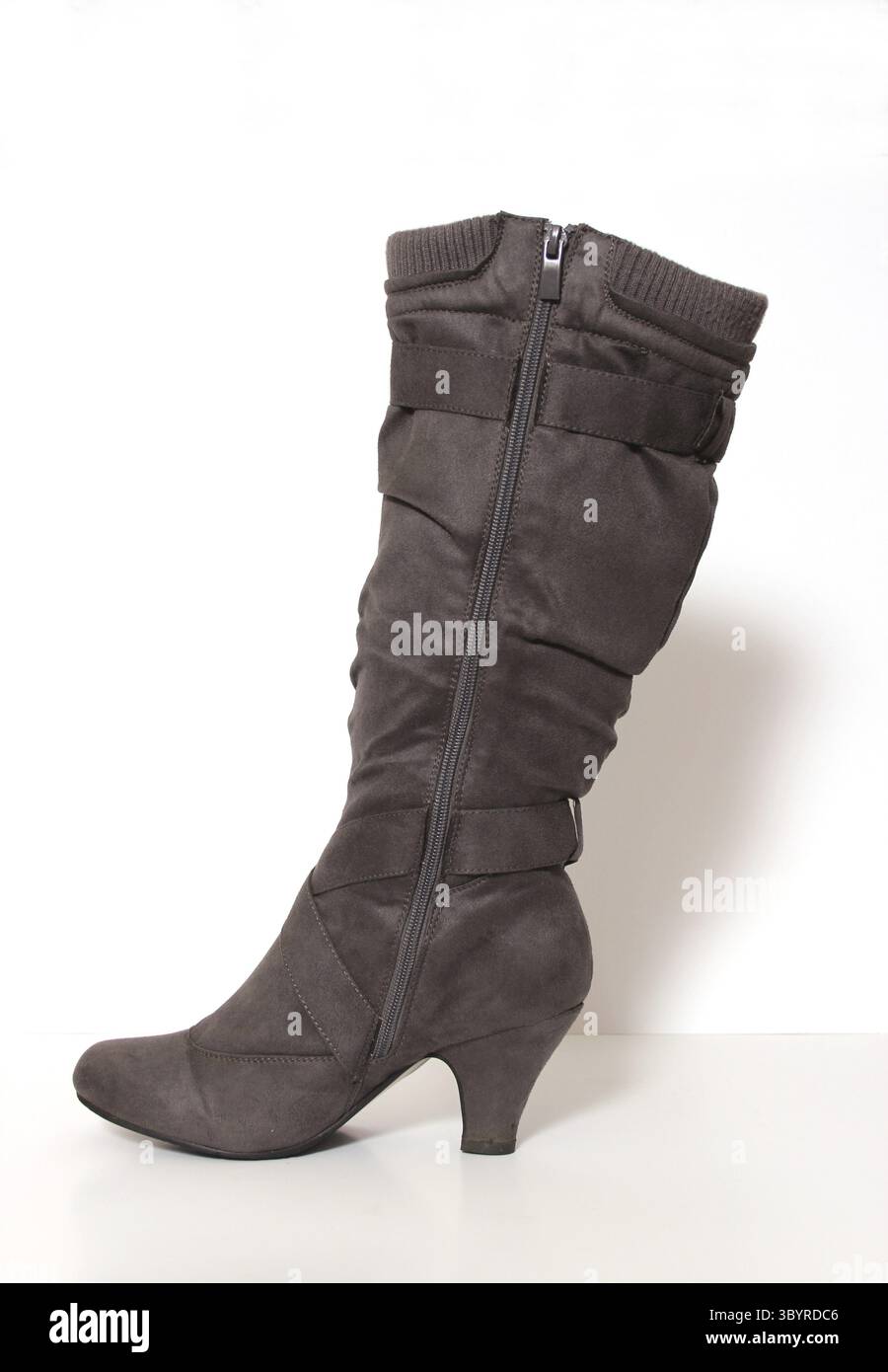 Grauer kniehoher Wintermode-Stiefel auf weissem Hintergrund Foto Stock