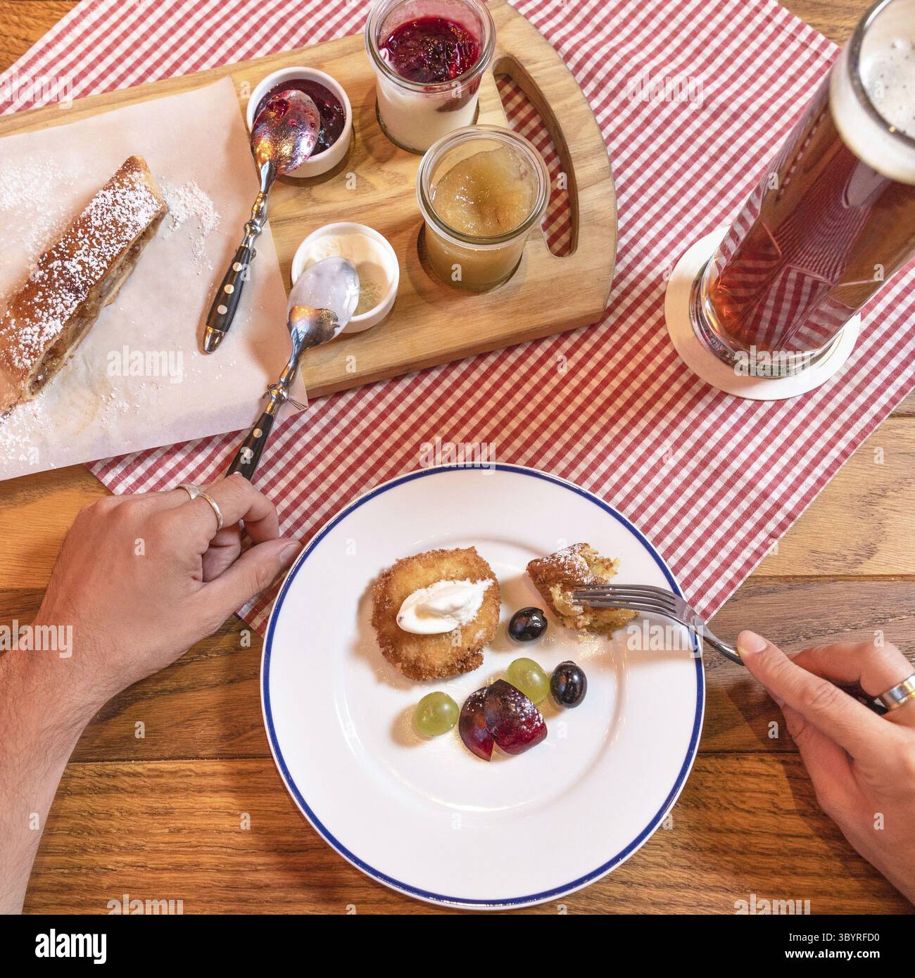 Uomo che mangia marmellata dolce dessert spuntino con birra scura e nera Foto Stock