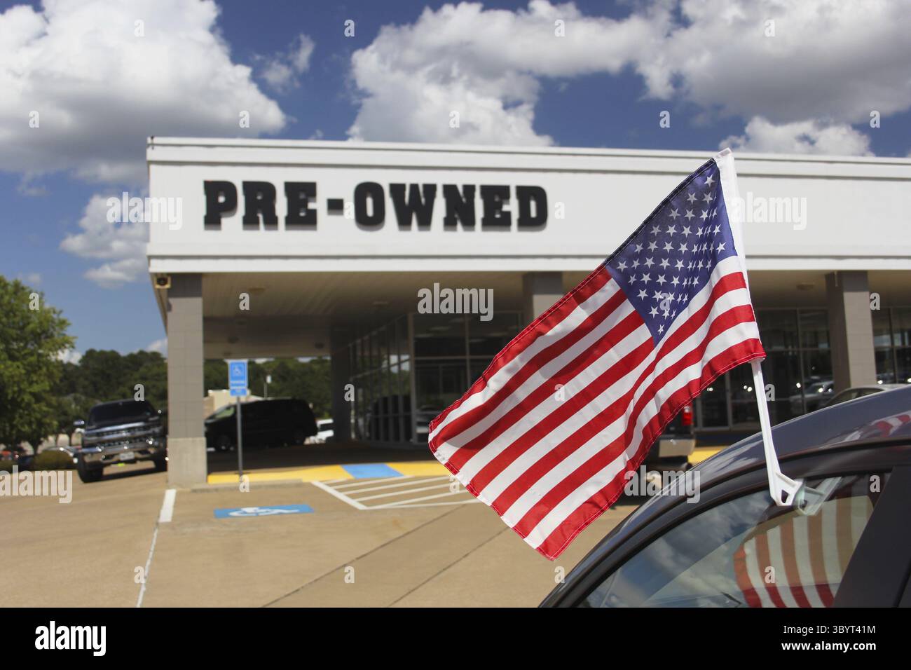 Concessionario di automobili usato con American Flag Shallow DOF, Focus su flagpole Foto Stock