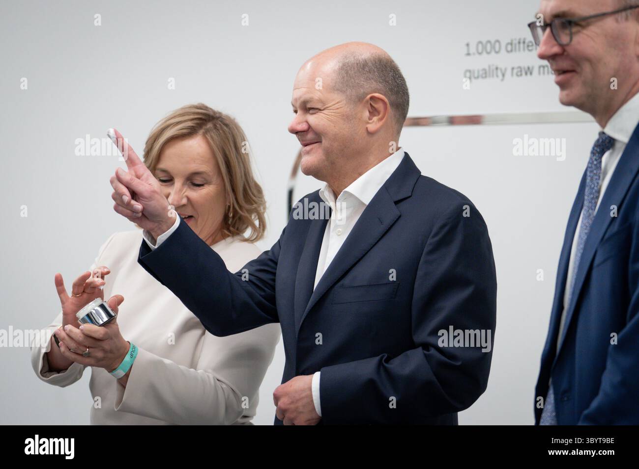 25 gennaio 2024, Eschweiler, Nordrhein-Westfalen, Germania: Eschweiler (Germania), 25/01/2024.- il Cancelliere tedesco Olaf Scholz (C) con la crema al dito si trova accanto ai proprietari della Barbor Beauty Company Isabel Bonacker (L) e del Dr. Martin Grablowitz (R) nel nuovo stabilimento di produzione vicino a Eschweiler, Germania, 25 gennaio 2024. (Alemania) (immagine di credito: © Jutta Prechtel/POOL via ZUMA Press Wire) Foto Stock