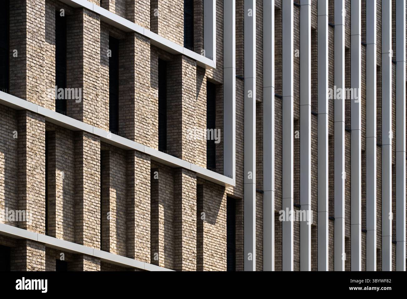 Facciata in mattoni e alluminio con ritmo verticale e giochi leggeri Foto Stock