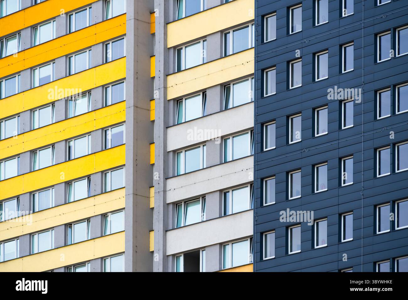 Torri residenziali a righe con strati orizzontali gialli, grigi e blu scuro Foto Stock