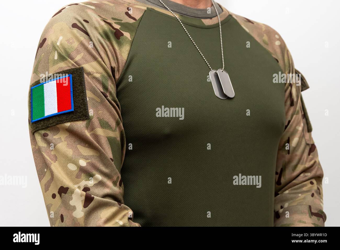 Un soldato camuffato con una bandiera italiana e stemmi militari intorno al collo Foto Stock