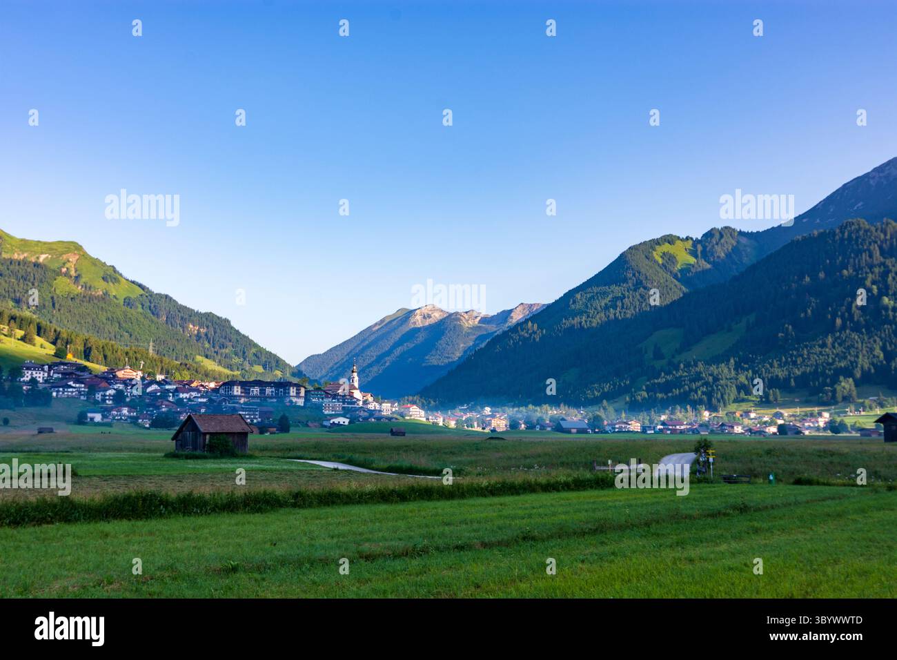 Lermoos: Villaggio e chiesa Lermoos, prato, capannoni in Tiroler Zugspitz Arena, Tirolo, Tirolo, Austria Foto Stock