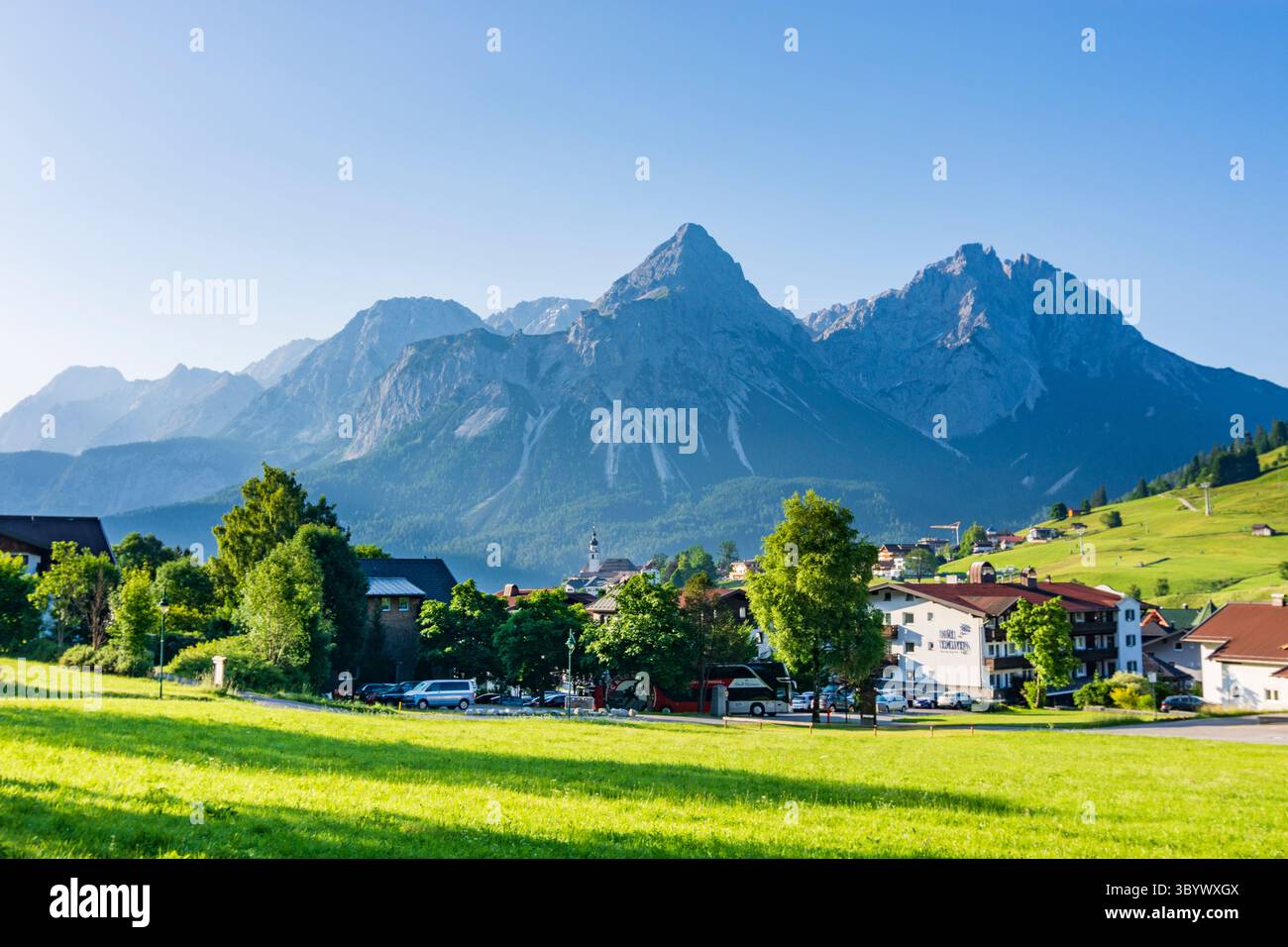 Lermoos: Villaggio e chiesa Lermoos, vista sul monte Ehrwalder Sonnenspitze nella Tiroler Zugspitz Arena, Tirolo, Austria Foto Stock