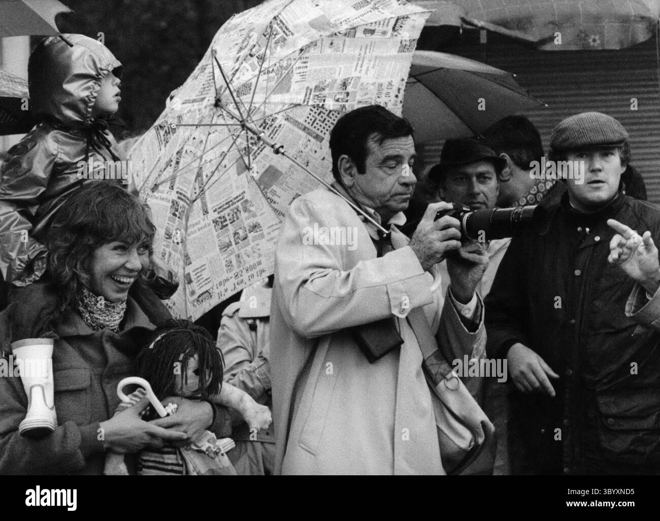 12 dicembre 1973 - la Top-Star Walter Matthau scatta foto in Heavy Raining all'Oktoberfest di Monaco/Germania Ovest.: Travestito da semplice passante, era sotto gli spettatori che volevano vedere l'arrivo dei padroni di casa all'"Oktoberfest" di Monaco/Germania Ovest. Rimani in giro con la macchina fotografica e l'ombrello come protezione per le piogge intense Walter Matthau (foto di Walter Matthau), la star americana e premio Oscar winne (il biscotto della fortuna) non è stato tanto gradito agli ospiti, ma la sua visita al festival è stata dedicata al suo lavoro per il suo nuovo film. L'arrivo è stato conduttivo a Foto Stock