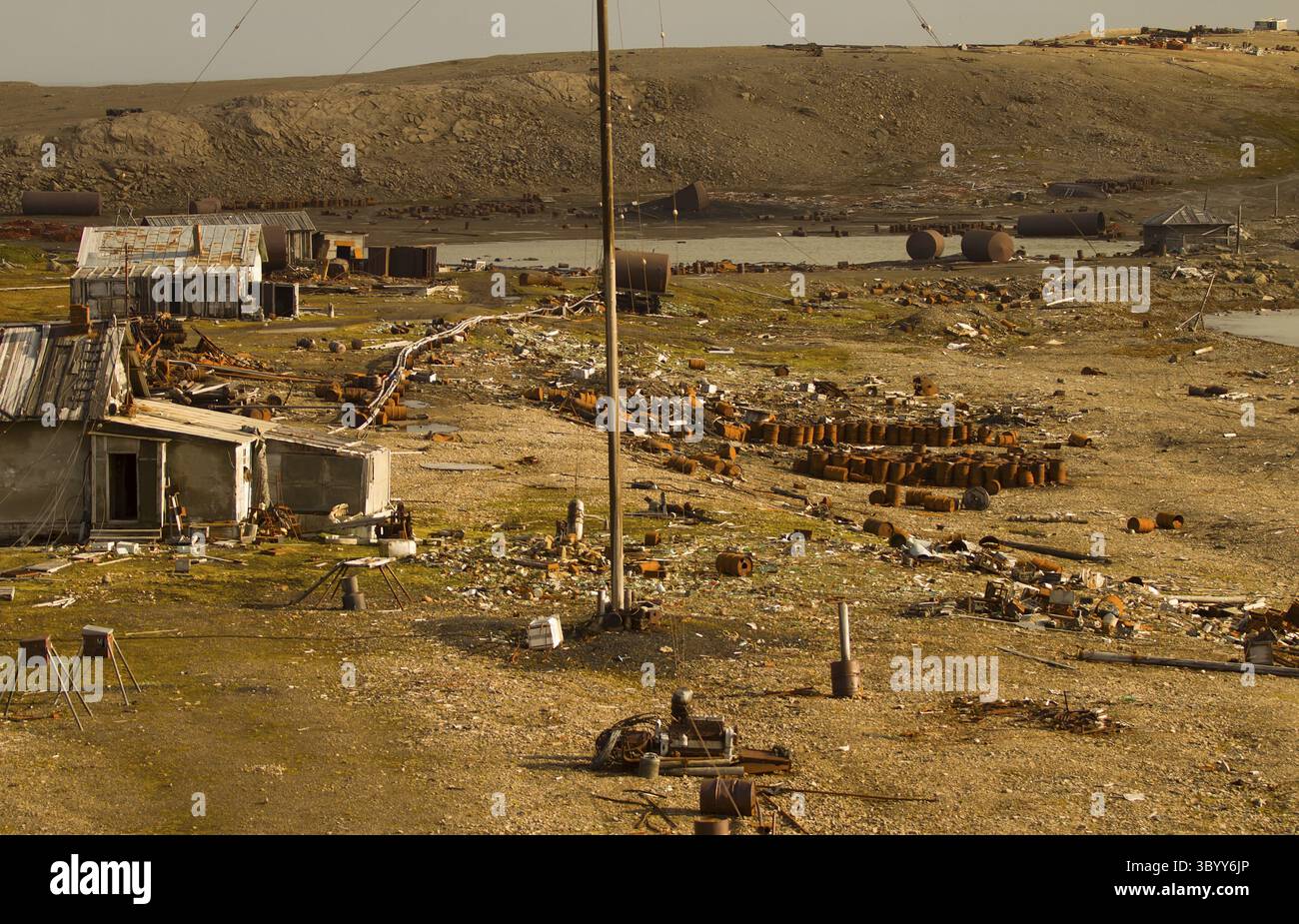 Stazione polare di Ollapsing nell'isola nord, l'isola di Novaya Zemlya. Un gran numero di barili di carburante abbandonati Foto Stock