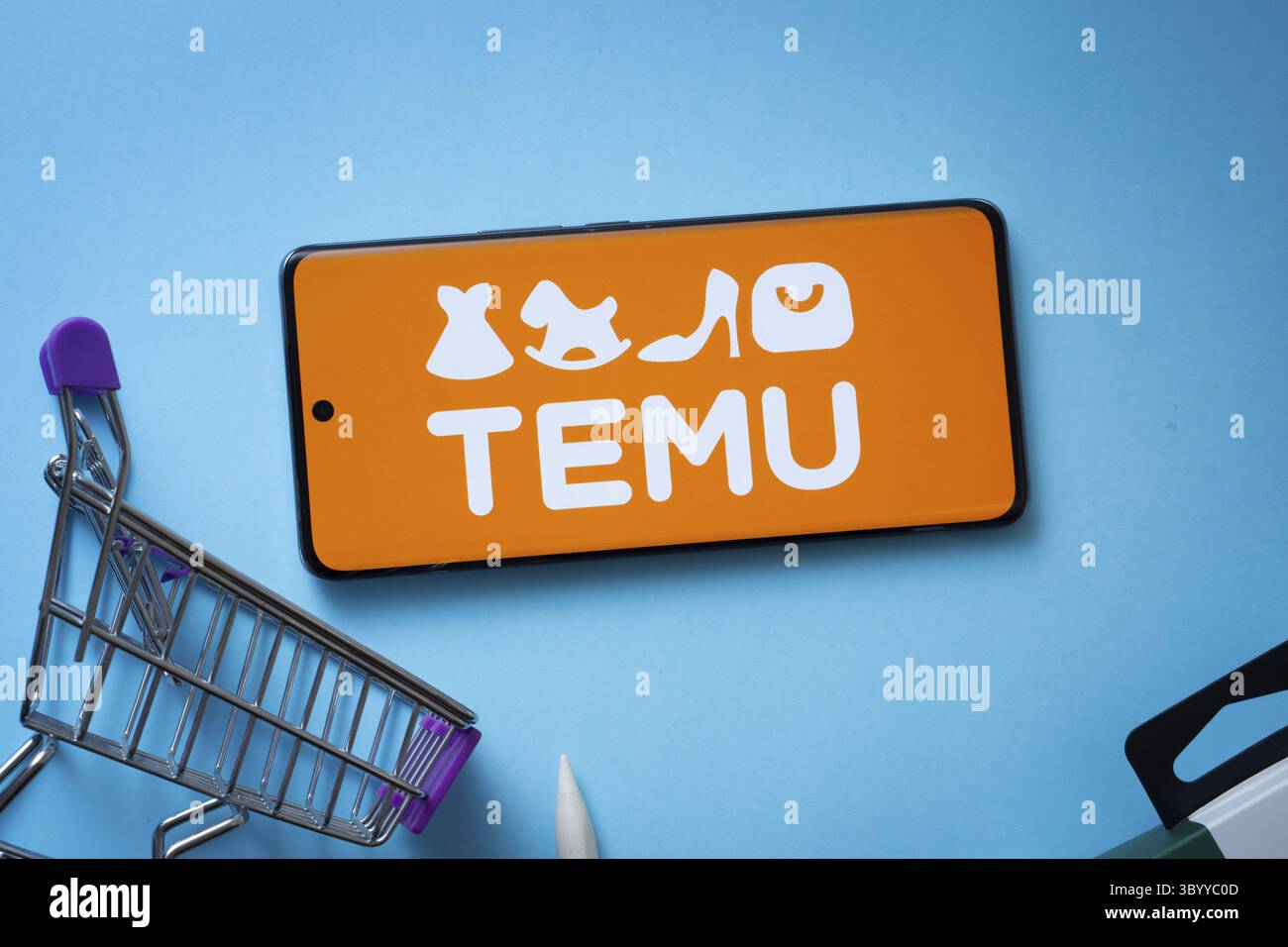 Dacca, Bangladesh - 3 luglio 2025: Smartphone con logo Temu e carrello su sfondo blu Foto Stock