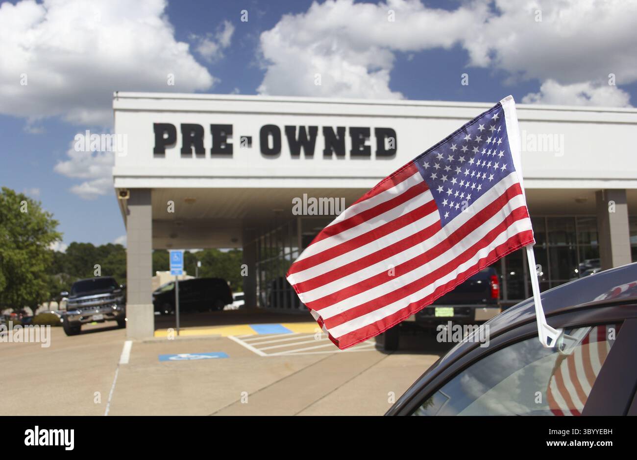Concessionario di automobili usato con American Flag Shallow DOF, Focus su flagpole Foto Stock