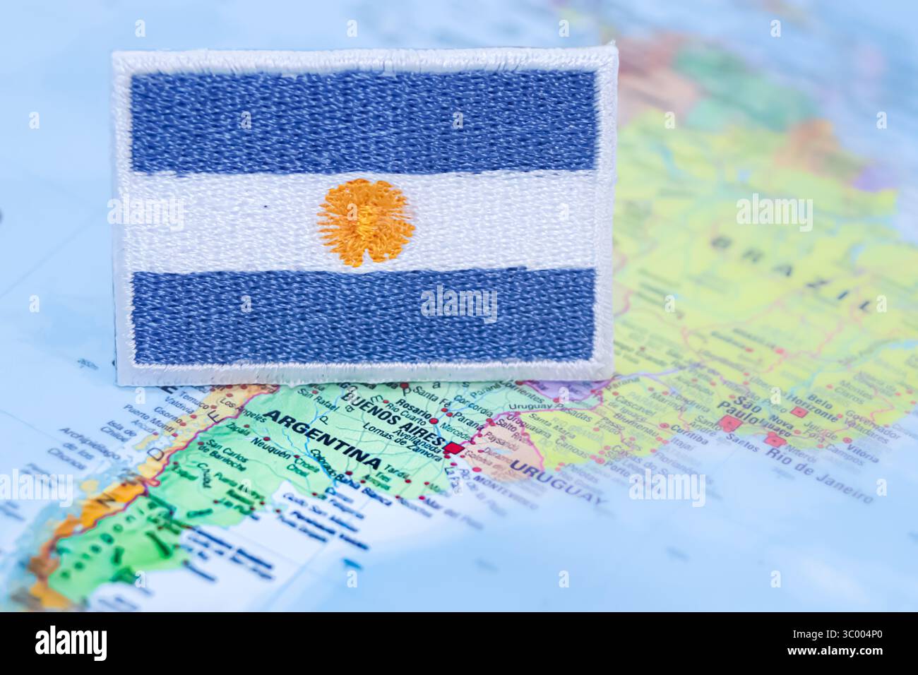 Bandiera argentina fatta a mano cucita con stoffa e filo su una mappa dell'Argentina. Ideale per viaggi d'affari, turismo ecologico e cultura globale. Foto Stock