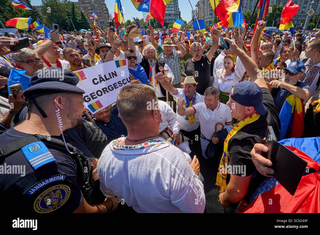 Bucarest, Romania. 20 luglio 2025: Persone in tradizionale abbigliamento rumeno gridano durante la protesta "Esci di casa se ti importa" organizzata dall'Alleanza per l'Unione dei rumeni (AUR) in Piazza della Vittoria, Bucarest. Crediti: Lucian Alecu/Alamy Live News Foto Stock
