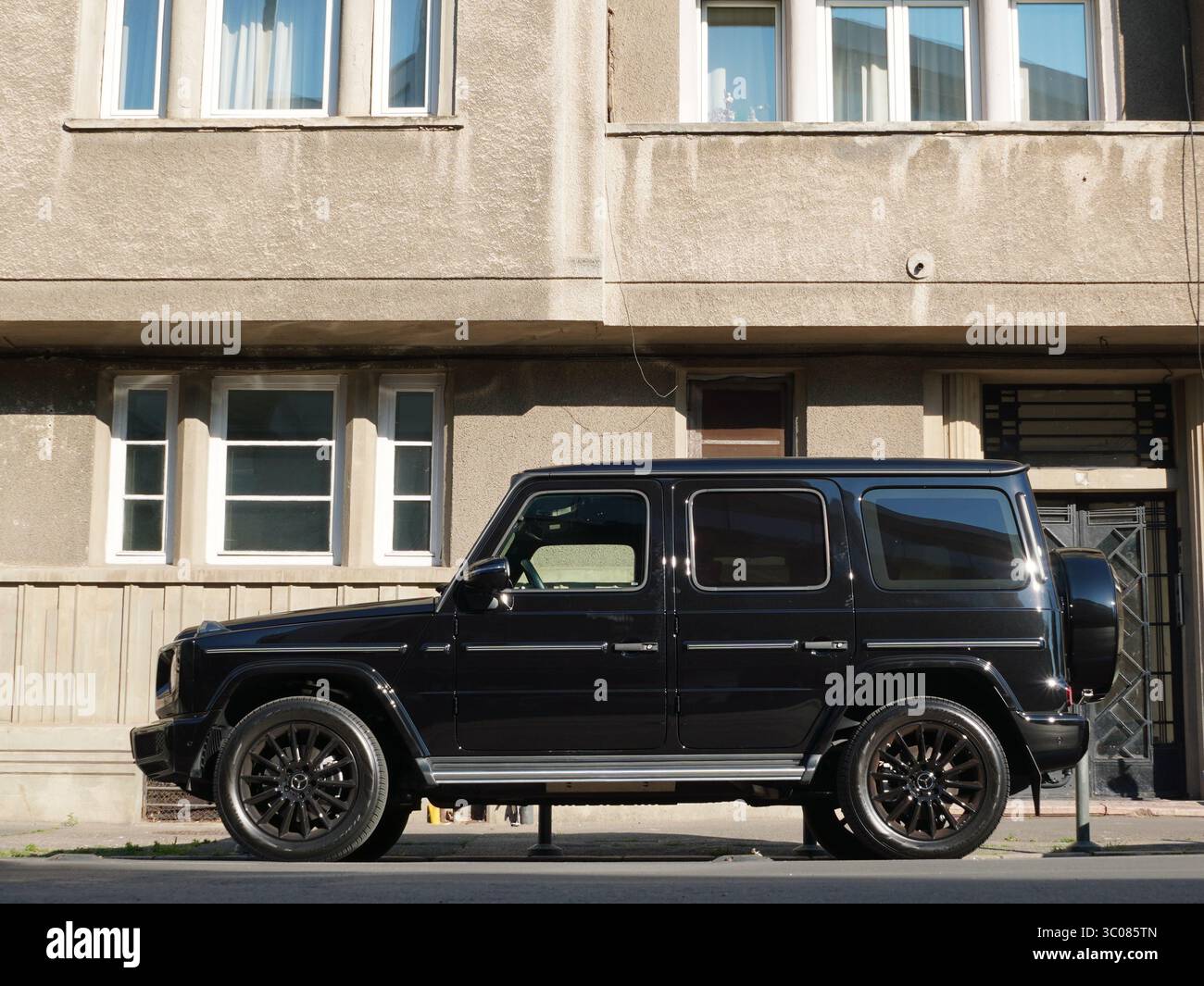 Bucarest, Romania – 20 luglio 2025: Vista laterale del SUV Mercedes-Benz G400d G-Wagon 4x4 nero parcheggiato in strada di fronte a casa in città Foto Stock