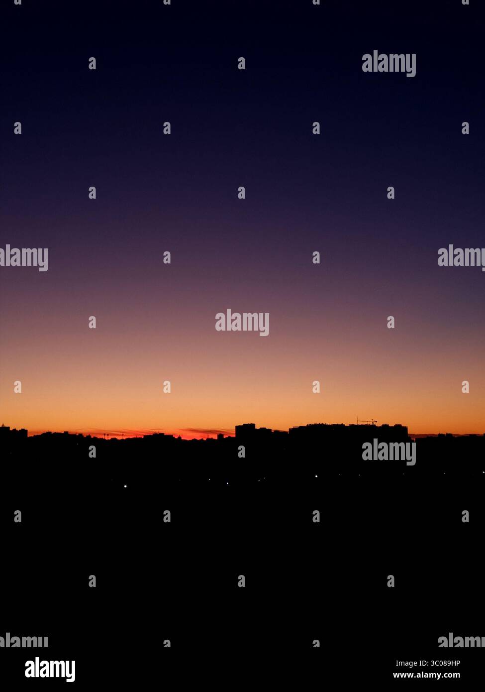 Crepuscolo sulla città. Sfumatura luminosa del cielo al tramonto sullo skyline urbano - sfumatura da arancione brillante a viola. Foto Stock