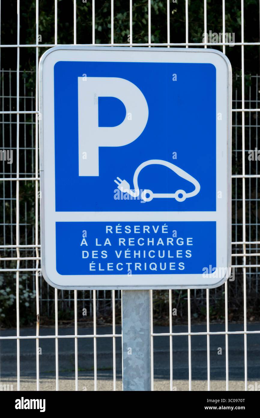 Un cartello francese avverte che un posto auto è riservato per la ricarica di veicoli elettrici. Foto Stock