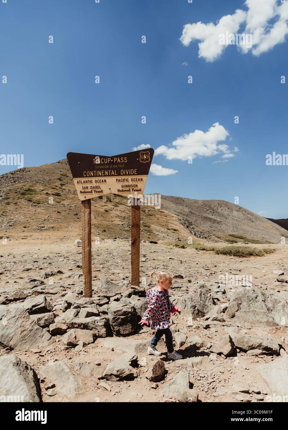 I bambini camminano di fronte al cartello TinCup Pass Continental divide Foto Stock